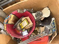 Box containing various fishing lures, fishing reels and small accessories.