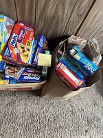 Boxes of plastic bags and paper goods including Hefty, Reynolds, Glad, Ziploc brands with some boxes open and visible contents.