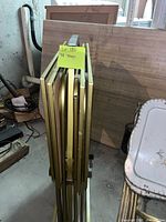 Two sets of vintage metal TV trays stored upright showing thin metal frames and trays between them.