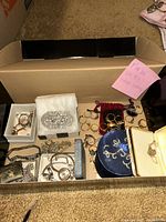 Overview of cardboard box with assorted jewelry pieces