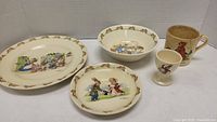 Four Bunnykins ceramic items shown together: bowl, two plates, egg cup, and old mug.