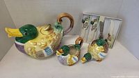 Photo showing the full set including the large duck teapot, two small duck containers, and boxed duck-handled knives.