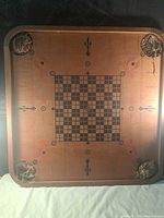 Face with checker-chess grid, visible decorative motifs and four corner pockets