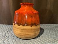 Front view of beige and orange drip glaze vase