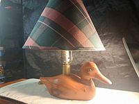 Full view of lamp showing carved wooden duck base, socket, plaid shade
