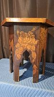 Overall view of wood side table showing floral pyrography and arched legs