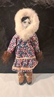Front view of doll showing outfit, face, boots and stand