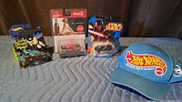 Group shot of all four items: Batman Batmobile, Coca-Cola Mercury, Star Wars car, Hot Wheels cap