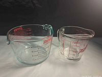 Both measuring cups side by side showing size difference and markings