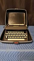 Typewriter seated in open carrying case