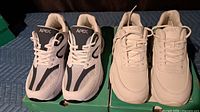 Both pairs of shoes on top of their green Apex boxes