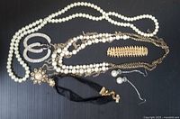 Full view of all costume jewelry pieces together on a black background, showing necklace strands, earrings, brooch, hair comb, and choker