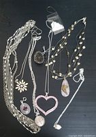 Overview photo of assorted vintage pendants and necklaces on black background