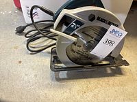 Front angled view of Black & Decker circular saw showing 2 1/3 HP labeling and blade with 40 teeth, power cord visible.