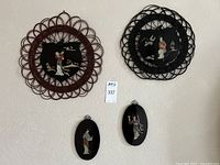 View of all four Chinese wall plaques, two large round with lattice borders and two smaller oval plaques, all with stone inlay depicting traditional figures and nature scenes.