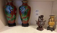 Overview of all items: two red cloisonné vases with blue chrysanthemum and two soapstone urns on wood stands