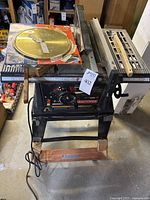 Full view of Craftsman table saw with extra blade and guide on top, showing saw base and wheels.