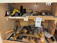 Shelf with assorted hand tools including hammers, pry bars, and wood mallet.