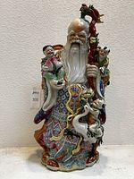 Front view of large Chinese porcelain Shouxing figurine with children and decorative robe.
