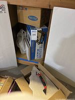 Boxed Workforce 7-inch tile wet saw under shelf surrounded by boxes and tiles.