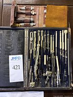Complete vintage drafting tool kit in black box with ivory or bone handled compasses, dividers, pencils, and wooden rulers arranged inside
