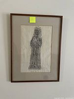 Photo of a framed rubbing of a medieval civilian figure from Dorchester Abbey circa 1513, in a brown wooden frame with beige mat.