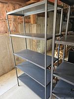 Single metal shelving unit showing five adjustable shelves and metal frame in basement environment.