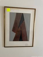 Framed abstract artwork by unknown artist with muted brown, black, and grey geometric shapes, matted and in gold frame.
