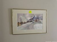 Framed watercolor painting showing a winter scene with snow and buildings by Jim Weller.