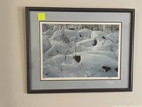 Framed art print of a snowy owl in a snowy landscape, professionally displayed in a dark wooden frame with double matting.
