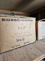 Cardboard box labeled 'SIDBEC-DOSCO' containing 3.5-inch Spiral Standard nails, 50lb net weight.