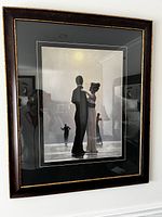 Front view of framed print showing dancing couple in black and white with other couple in background. Frame has black and gold trim.