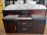 Front view of the bench with both padded seats in place, showing dark wood finish and vertical ribbed drawer fronts with metal handles.