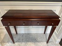Front view of console table showing two drawers, tapered legs and parquet-patterned top