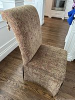 Side view of the Bombay Co. Parson dining chair showing the fabric upholstery and skirted bottom.