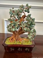 Full view of the faux jade bonsai tree showcasing green stone leaves, brown textured trunk, and the rectangular pot with Chinese characters.