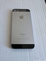 Back of the original iPhone SE showing Apple logo and model branding in space gray color on a two-tone metal and glass back panel.