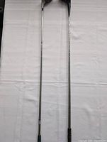 Full view of two golf club shafts showing steel shafts and grips
