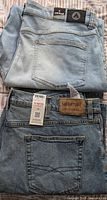 Folded light blue Aeropostale full length jeans and Levi's Signature full length jeans showing back pockets and labels