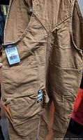 Rear view of brown Dickies work overalls highlighting back pockets and fabric texture with attached size and brand tags.