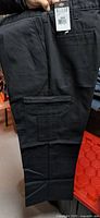 Front side of black Dickies cargo work pants showing pockets and fabric texture.