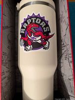 White 40oz cup with Toronto Raptors logo inside original packaging box.