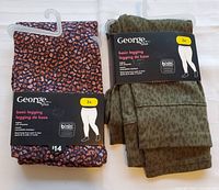 Front view of the two pairs of George Plus basic leggings in original packaging, one in multicolor animal print and one in olive green leopard print.
