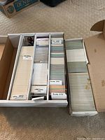 Boxes of baseball cards organized by year and brand showing OPC 1992, OPC Pacific 1991, Upper Deck 1991, Score 1990, and Score 1988 labels
