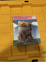 Photos of the sealed boxed Bunny Towne Easter House collectible showing front view with product image and label.
