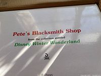 Close-up photo of the box label indicating the item is from the Disney Winter Wonderland collection, named Pete's Blacksmith Shop.