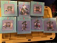 Six Easter Jubilee ceramic bunny family sets in pastel green original packaging, displayed on a yellow plastic surface.