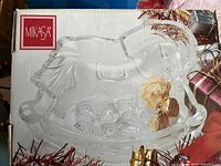 Box and packaging featuring Mikasa logo with the crystal rocking horse inside displayed with decorative holiday accents.