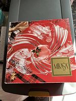 Top view photo of the Mikasa holiday glass platter in its original red box featuring embossed Santa Claus design and gold Mikasa logo.