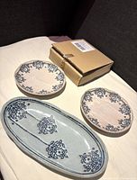 Top down view showing 2 canapé plates, 1 serving dish, and original cardboard box.